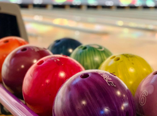 close-up of bowling ball return with multicolor bowling balls