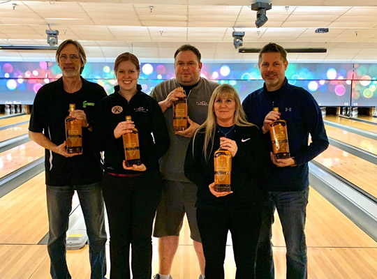 group of co-workers standing on the bowling lanes