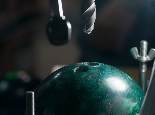 bowling ball being worked on in a pro shop